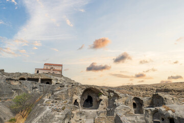 Fototapeta premium Uplistsikhe cave town near Gori city in Georgia. Ancient cave city Uplistsikhe at sunset in Georgia, UNESCO site. 