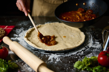 Preparing homemade pizza with fresh ingredients in the kitchen
