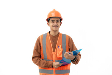 Young Indonesian male construction worker in full safety suit standing confidently holding clipboard, construction and industry concept, isolated on white background.