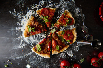 Freshly baked pizza with tomato and basil on rustic wooden table