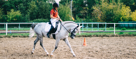 Caucasian active sportswoman riding on beautiful breed horse enjoying hobby practising during...