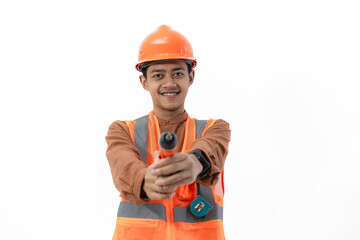 Young Indonesian male construction worker in full safety gear posing using drill, construction and industry concept, isolated on white background.