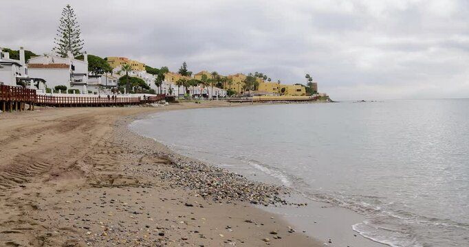 Footage showing the beach in the town of Sitio de Calahonda in Spain in the winter time showing the empty beach in December on a cloudy day
