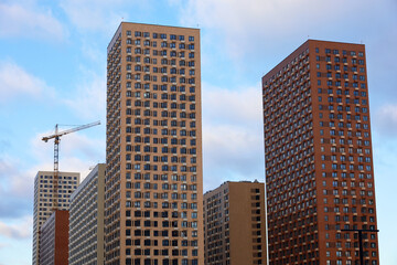 Obraz premium New buildings and tower crane. Housing construction, apartment blocks in city
