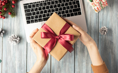 Christmas gift. Top view of woman holding traditional decorated gift box.