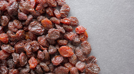 Close up photo of organic raisins on a dark slate background, selective focus.