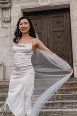 Elegant Bride gracefully poses on the Stairs wearing a Beautiful Wedding Dress