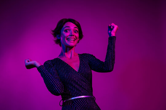 Photo portrait of pretty young girl raise fists excited winning wear trendy overall outfit isolated on neon light pink color background - Powered by Adobe