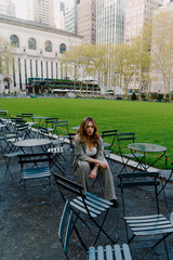 Woman relaxing in urban park, surrounded by modern cityscape