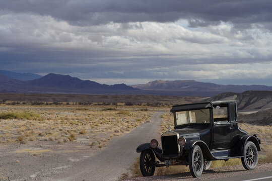 1926 Model T Ford vintage car parked by a roadside in the Mojave Desert, California, USA, November 26, 2024. The classic automobile rests against an arid desert backdrop with cloudy skies..