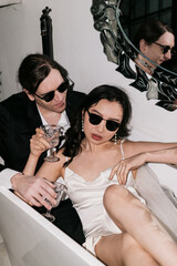 Chic Couple Sitting Together and Enjoying Drinks in a Beautiful Modern Bath Setting