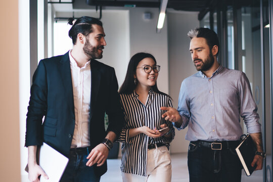 Cheerful employees discussing project in corridor