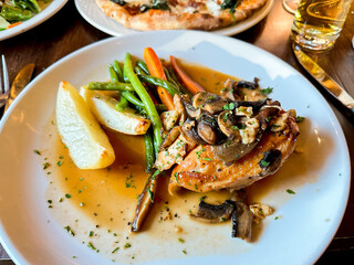 Delicious chicken dish served with vegetables and potatoes at a cozy restaurant