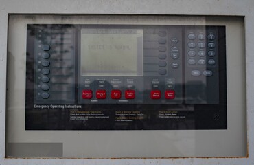 The fire alarm panel is attached to a concrete wall.