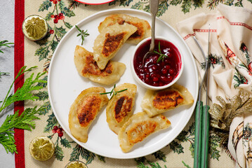 Traditional Polish fried pierogi with duck and cranberry sauce on a plate..style hugge.