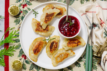 Traditional Polish fried pierogi with duck and cranberry sauce on a plate..style hugge.