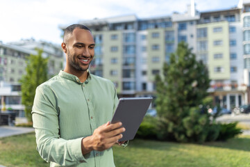 Fototapeta premium Businessman with tablet standing near buildings checking built project