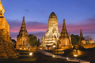 Fototapeta premium Wat Chaiwatthanaram temple at Ayutthaya in Thailand. Sunset scenery sky view in winter season. Tourism wearing traditional Thai clothing. Place of landmark popular of tourist.