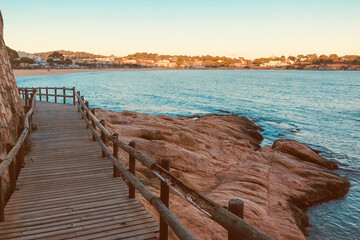 Fototapeta premium Wooden Boardwalk by the Scenic Rocky Coastline