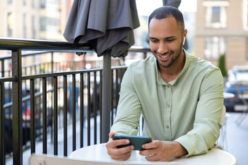 Smiling African American man using smartphone outdoor