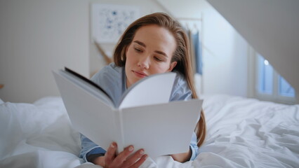 Tranquil girl enjoy reading book in bed absorbed content closeup. Woman relaxing