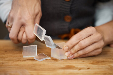 close-up of hands of mother helps her little child girl using knife for preparing hand-made soap, art workshops for children.