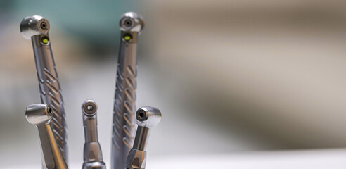 Dental hand instruments used in dental treatments. A rotary handpiece fitted with a bur, used to cut and abrade enamel tissue. Tooth decay and root canal treatment.  © UniqDream