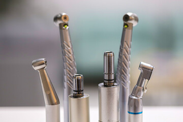 Dental hand instruments used in dental treatments. A rotary handpiece fitted with a bur, used to cut and abrade enamel tissue. Tooth decay and root canal treatment.  © UniqDream