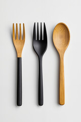 A set of three wooden spoons and a fork on a white surface