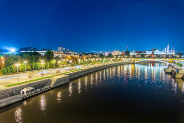 Illuminated Moscow Kremlin and Bolshoy Kamenny Bridge at summer night. View from the Patriarshy pedestrian Bridge