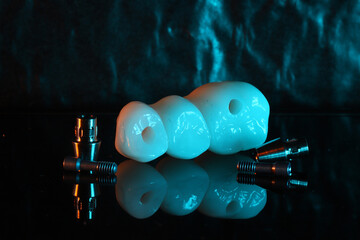 In dental and cosmetic dentistry, bone-anchored dental implant treatment with porcelain bridge prostheses and implant screws.  © UniqDream
