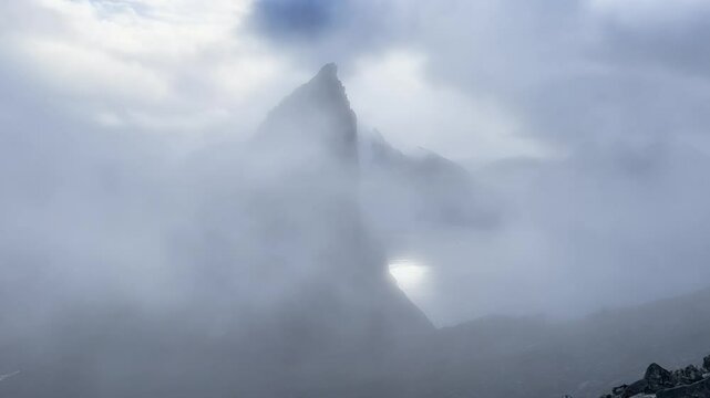 Fog is surrounding a Segla peak over the ocean in Senja, Norway