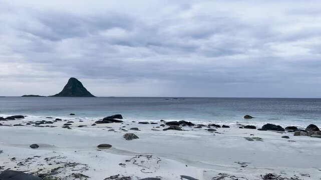 White sand beach with turquoise ocean water and a mountain in Bleik beach, Lofoten islands, Norway
