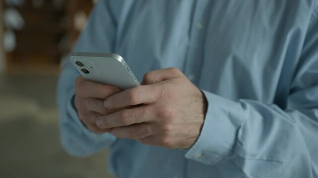 Close up Caucasian businessman man business client user client male hands typing message texting holding mobile phone cellphone using smartphone scrolling browsing internet online apps indoors office