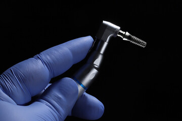 The handheld tool used in dental dentistry for the treatment of missing teeth and the dental implant at its tip. Dental implants are placed into the bone through jaw and oral surgery.