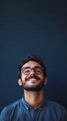 Fototapeta premium nerdy man with glasses smiling at camera on dark blue background with copy space vertically 9:16