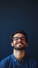 Obraz premium nerdy man with glasses smiling at camera on dark blue background with copy space vertically 9:16