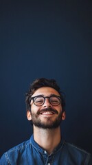 nerdy man with glasses smiling at camera on dark blue background with copy space vertically 9:16
