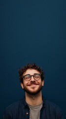 Obraz premium nerdy man with glasses smiling at camera on dark blue background with copy space vertically 9:16