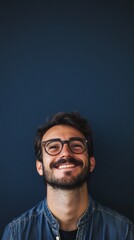 Obraz premium nerdy man with glasses smiling at camera on dark blue background with copy space vertically 9:16