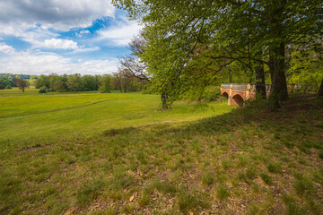 Idyllic Countryside Meadow with a Historic Brick Bridge and Trees