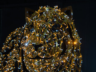 Close up view of a christmas tiger decorated with yellow lights.