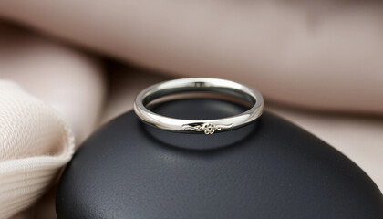 A delicate silver ring showcasing a small flower detail, elegantly displayed against a soft background. Perfect for fine jewelry lovers seeking simple elegance and charm in their accessories.

