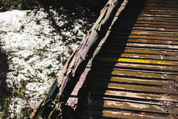 Detail of a rustic wooden footbridge above the sparkling waters of the Pecos River, New Mexico