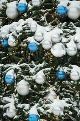 Christmas balls and luminous garland on a Christmas tree in the snow