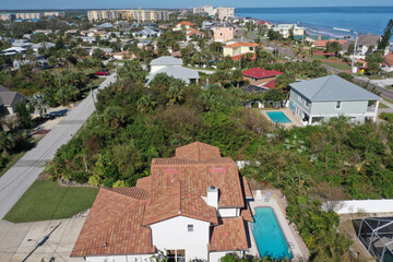 Aerial looking north over New Smyrna Beach, Florida neighborhoods, beachfront hotels and condos and the Atlantic Ocean.