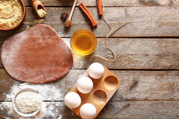 Fresh dough and ingredients for gingerbread cookies on brown wooden background