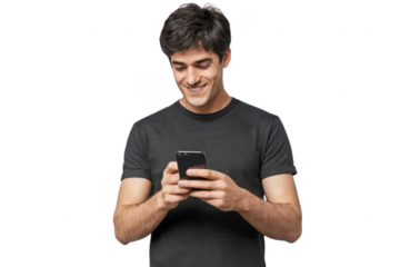 Young man standing, looking at screen of phone with smile, browsing web pages or chatting with friend
