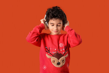 Cute little boy in headphones orange background