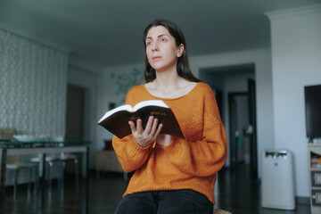 Young woman enjoying a quiet moment of reading at home in natural light